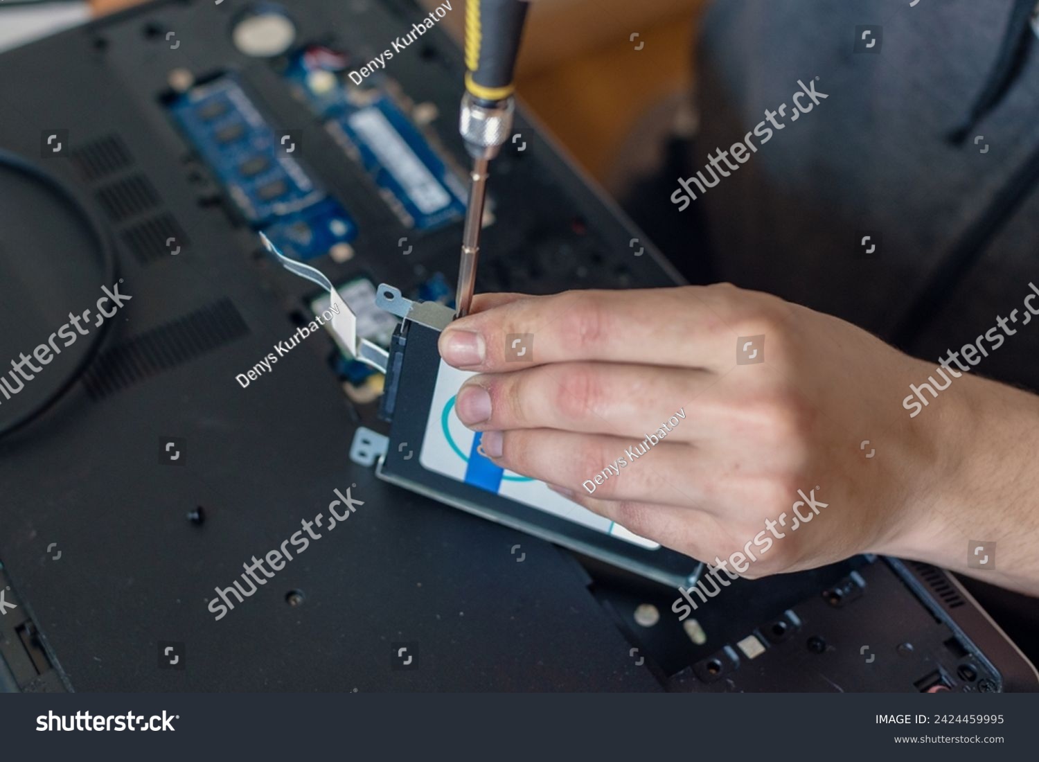 stock photo closeup photo of male technician with screwdriver replacing hdd disk of laptop hard disk rescue 2424459995